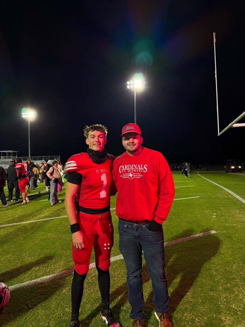Brayden Smith and Patrick Bauer standing together on a football field under the Friday night lights